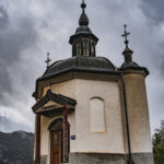 Vue en contre-plongée de la chapelle de Longefoy sous un ciel nuageux
