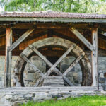 Roue du moulin à eau de Longefoy sous une ancienne charpente en bois