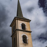 Clocher de l'église de Tessens sous un ciel nuageux