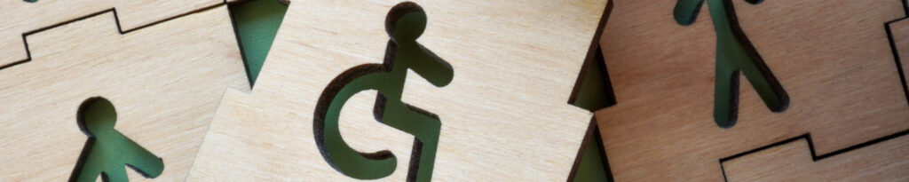 Pièces de puzzle en bois, dont l'une comporte un symbole d'accessibilité pour les fauteuils roulants, disposées ensemble.