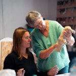 Deux femmes dans un atelier d'art, l'une façonnant de l'argile tandis que l'autre observe attentivement.