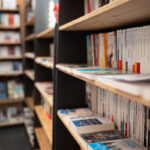 Étagères remplies de livres divers dans une librairie, vues sous un angle latéral.