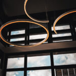 Des suspensions circulaires sont suspendues près de grandes fenêtres avec une vue sur les montagnes en arrière-plan.