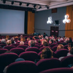 Public assis dans une salle de cinéma.