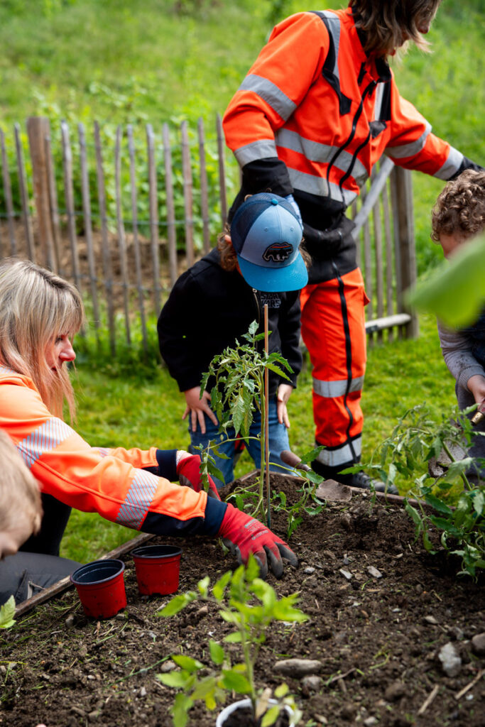 Employées aux espaces verts de la commune plantant un arbre avec des enfants