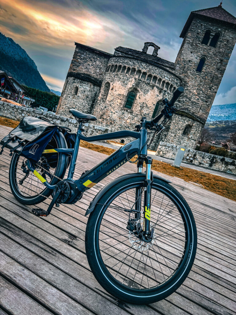 Vélo électrique avec des sacoches devant la basilique, sur le théâtre de verdure