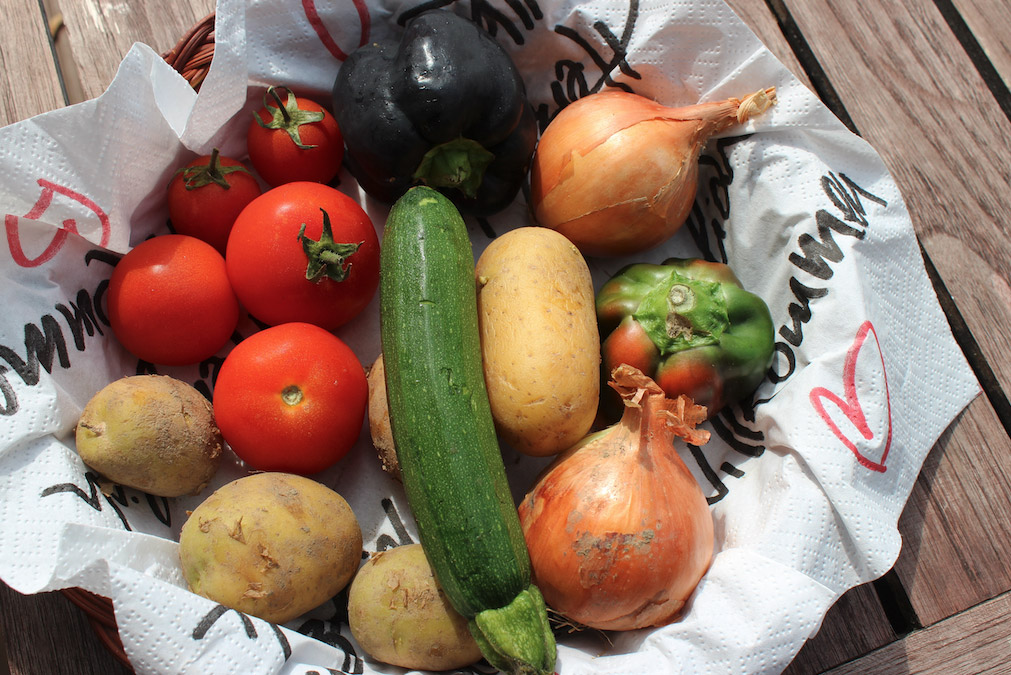 Photo de légumes (tomates, pommes de terre, courgette, oignon...) dans un panier