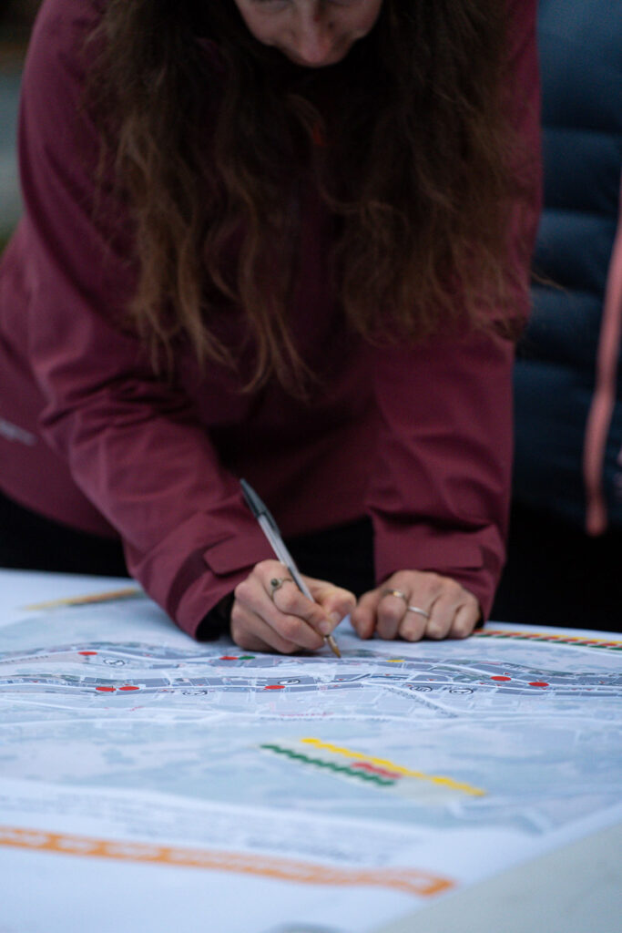 Femme écrivant au stylo sur un plan type cadastrale