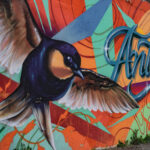 Graffiti artistique représentant un moineau sur un mur devant le parking d'Antropia