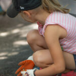 Petite fille avec des gants ramassant des déchets