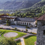 Vue sur la mairie et le théâtre de verdure avec la basilique d'Aime au premier plan