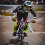 Jeune garçon sur son vélo, casqué et en habit de cycliste, sur les bosses de la pumptrack