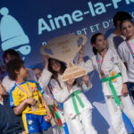 Des jeunes sportives et sportifs en kimonos de judokas, médailles au cou, se tiennent sur scène lors de la cérémonie de la Soirée des Champions à Aime-la-Plagne.