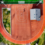 Vue aérienne de la piste d'athlétisme et des terrains de basket du stade de Albert Perrot, bordés à leur droite par la rivière Isère