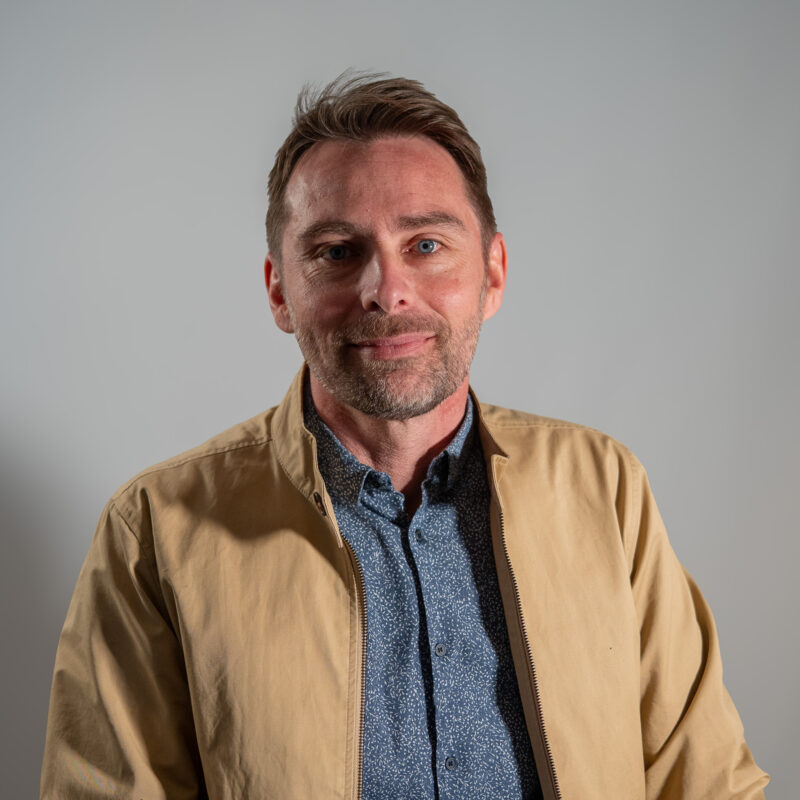 Sur un fauteuil en cuir noir repose une écharpe de Maire aux couleurs du drapeau français, bleu, blanc et rouge