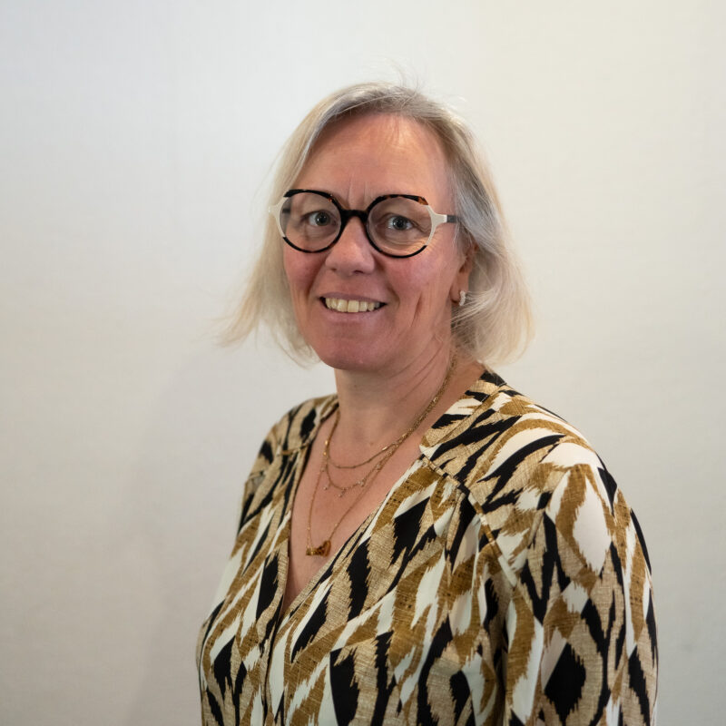 Sur un fauteuil en cuir noir repose une écharpe de Maire aux couleurs du drapeau français, bleu, blanc et rouge